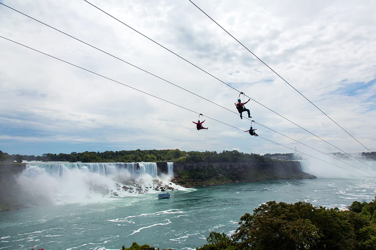 picture of people riding Niagara Falls Zipline and the falls in the background